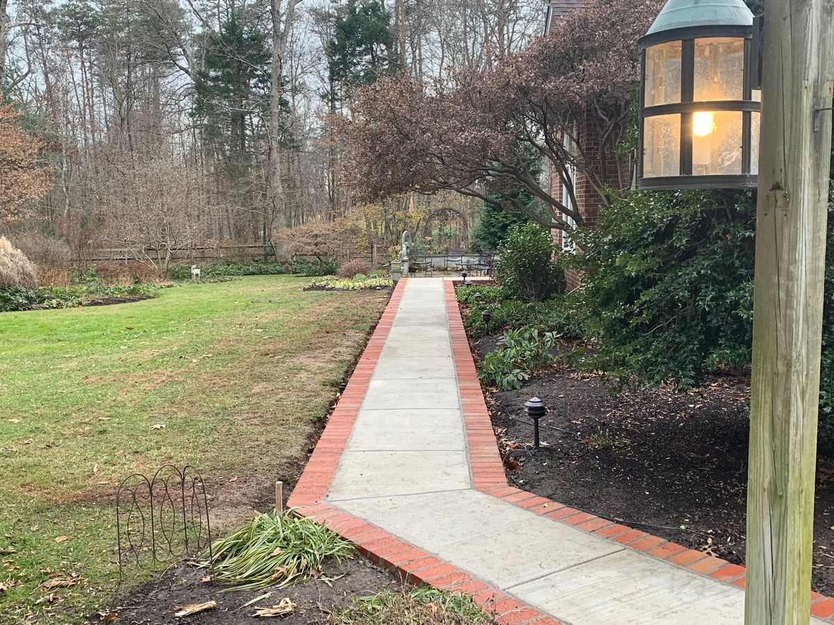 Brick bordered concrete walkway by MG Minor Construction in Warrenton VA
